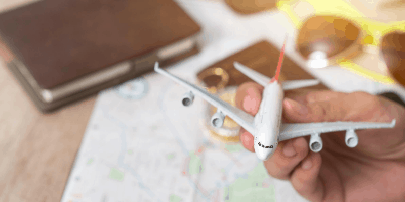 Holding a plane toy while planning trip