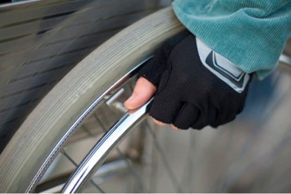 Person on a wheelchair with mesh gloves