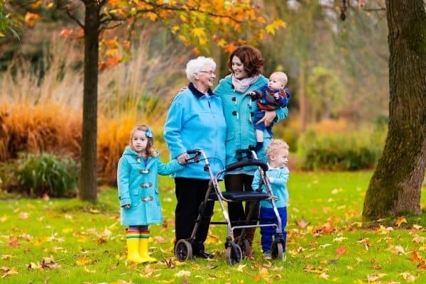 Elderly on rollator with family