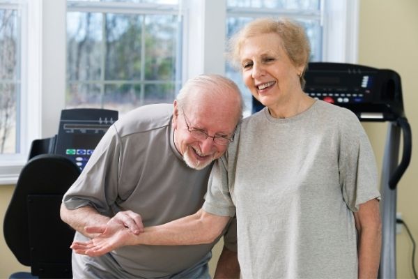 Senior couple with exercise equipment at home
