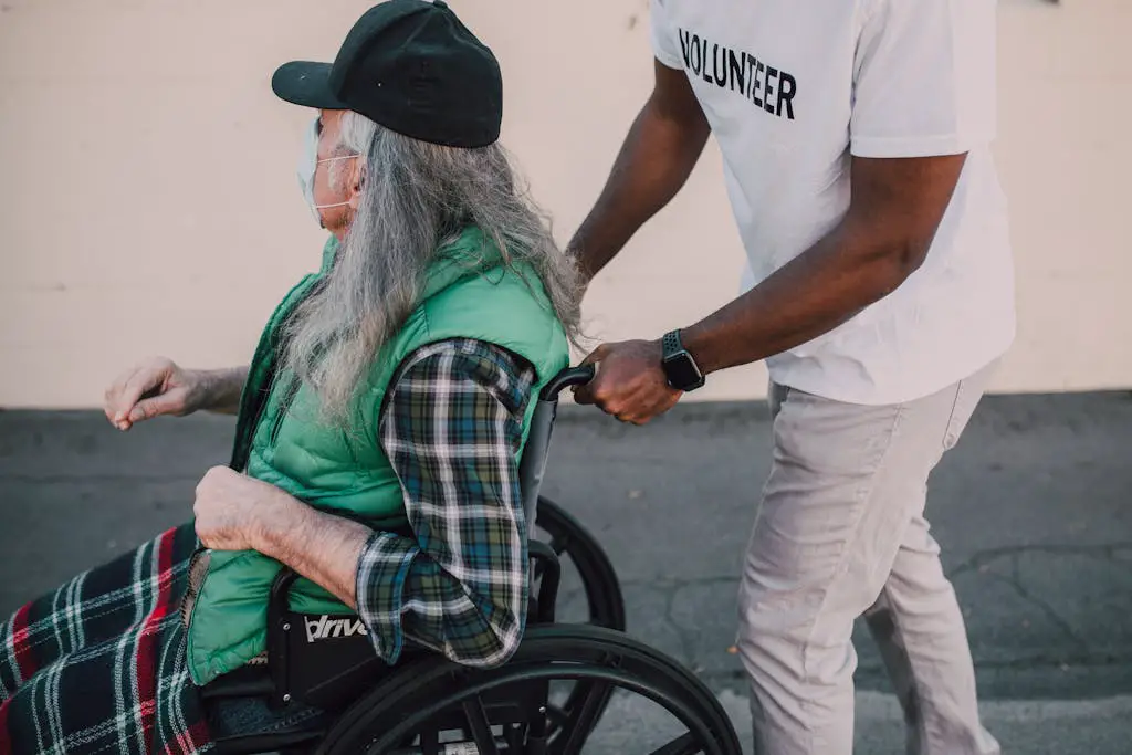 A volunteer helps a senior in a wheelchair during travel